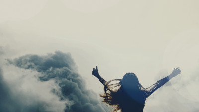 Girl silhouette above clouds